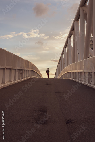 Man walking alone on the bridge. Photography symbolizes life journey, difficult choices and decisions, depression.