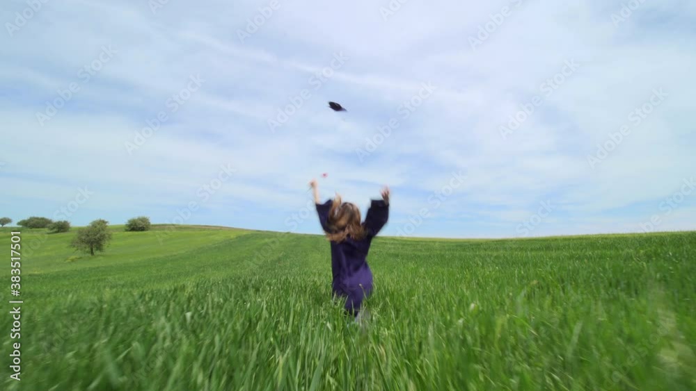 Graduation girl running alone in a green field with red tulip, throwing the cap in the air. Virtual graduation and social distancing concept. Graduation girl running alone in a green field with red tulip, throwing the cap in the air. Virtual graduation and social distancing concept.