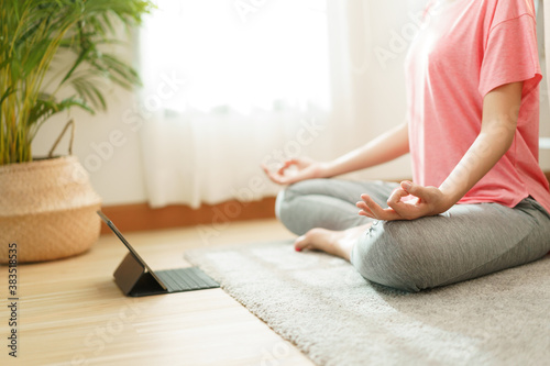Close up. hand woman doing yoga exercises with Training online on tablet at home 