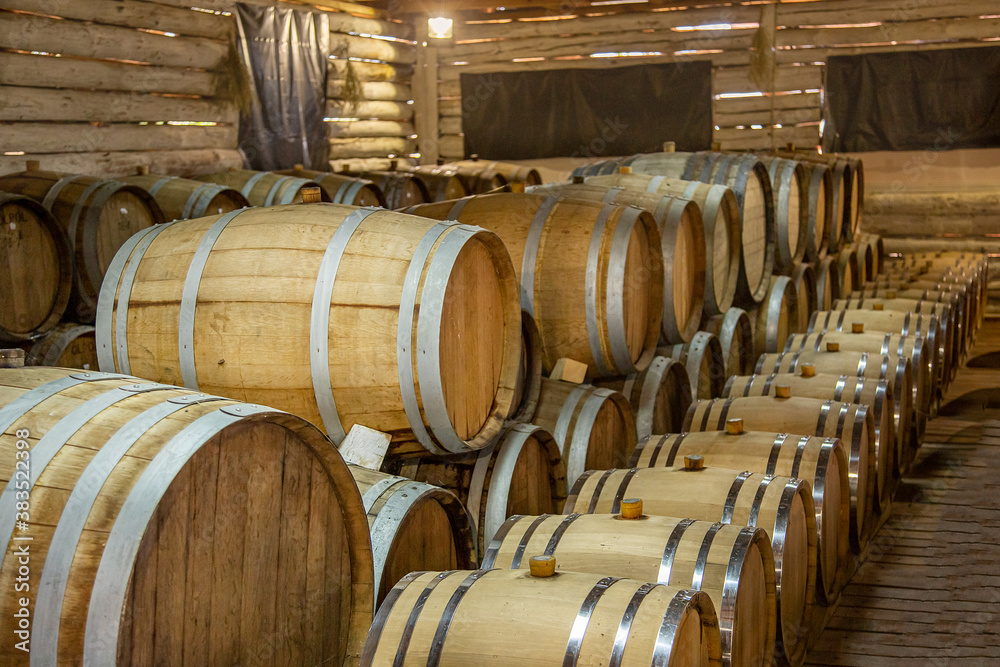 Wooden wine barrels are found at the winery. They are ready to pour or are already filled.
