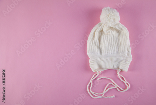 Winter warm hat on an isolated pink background. White hat.