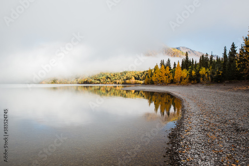autumn landscape with still lake, clouds and blue sky