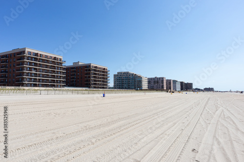 Fototapeta Naklejka Na Ścianę i Meble -  Big Beach along the Atlantic Ocean in Long Beach New York with a Boardwalk and Buildings during Summer