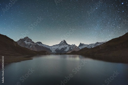 Incredible night view of Bachalpsee lake in Swiss Alps mountains. Snowy peaks of Wetterhorn, Mittelhorn and Rosenhorn on background. Grindelwald valley, Switzerland. Landscape astrophotography © Ivan Kmit
