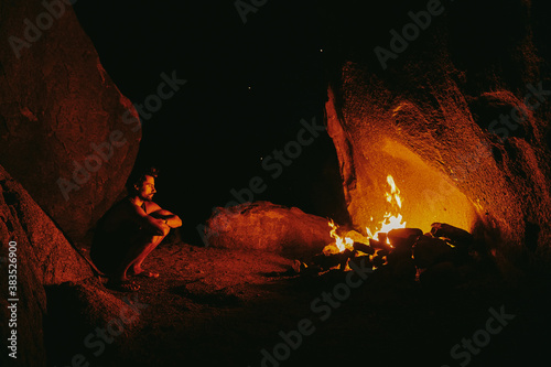 Young man in front of camp fire at night in northern California. photo