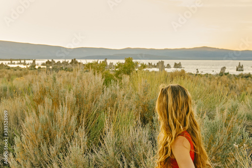 Young woman looking to Mono Lake during sunset in northen California photo