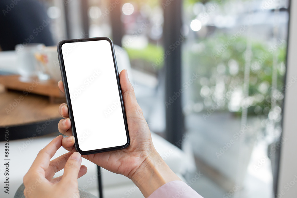 cell phone mockup blank white screen.woman hand holding texting using mobile on desk at coffee shop.background empty space for advertise.work people contact marketing business,technology