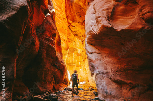 Young man wearing a hat, exploring a slot canyon in Kanarra Fall, Utah photo