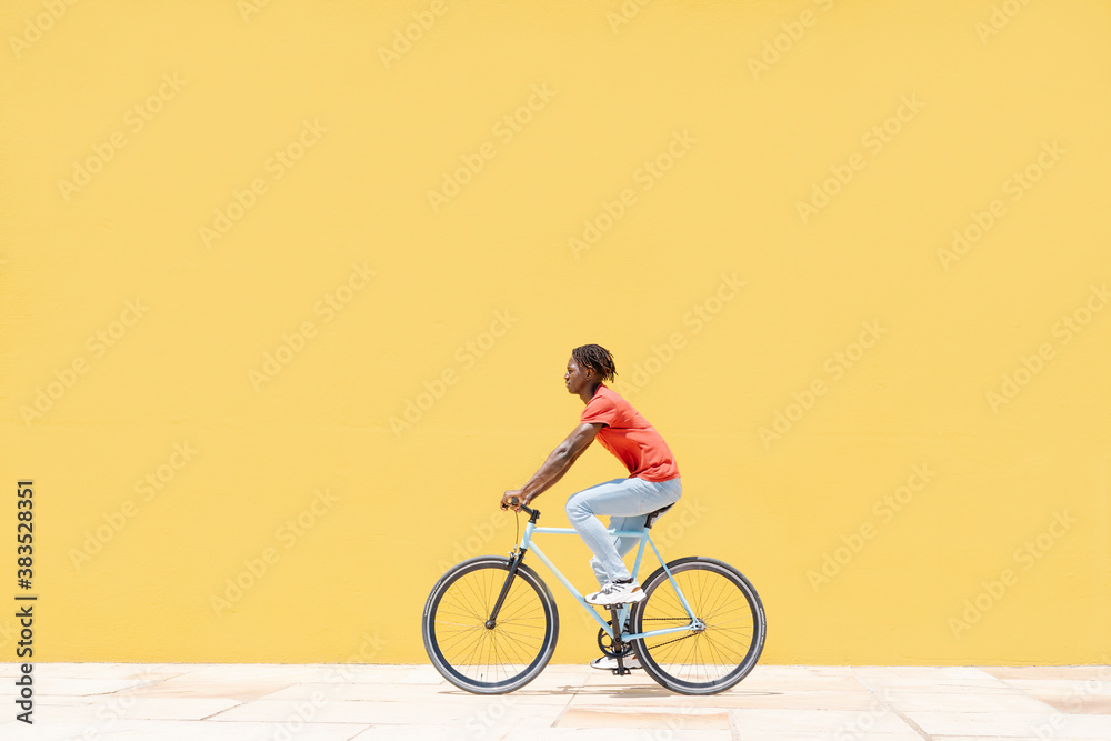 Side view of young man riding bicycle on pavement