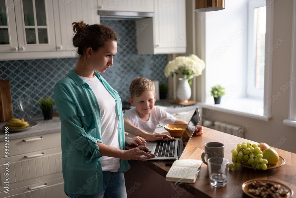 Mother working near eating son Mother working near eating son