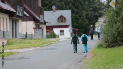 Wallpaper Mural Two children, brothers, walking on a path in a park, cloudy autumn day Torontodigital.ca