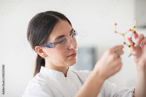 scientist female with lab glasses, tablet and sample in a lab photo