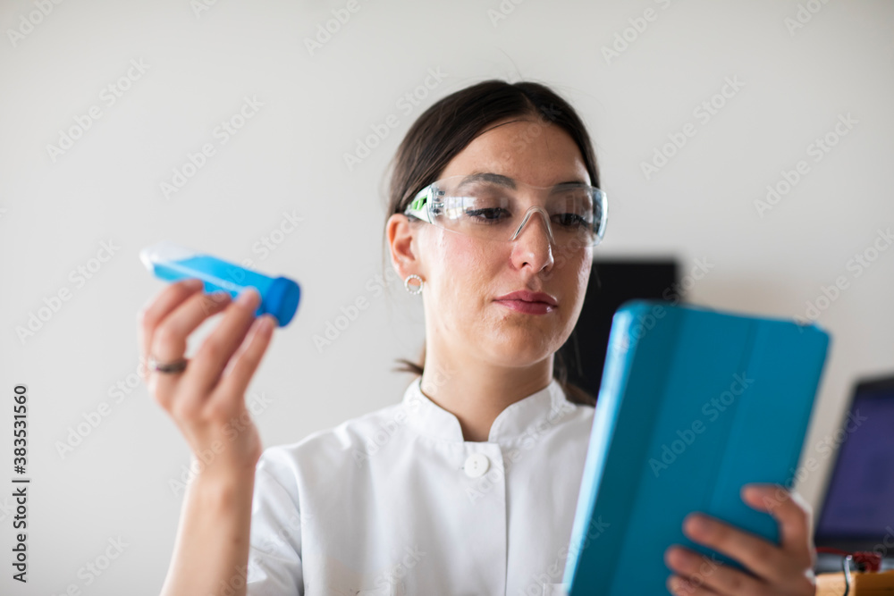 scientist female with lab glasses, tablet and tubes in a lab scientist female with lab glasses, tablet and tubes in a lab