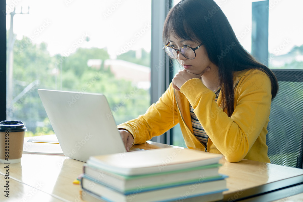 Young collage student using computer and mobile device studying online. Young collage student using computer and mobile device studying online.