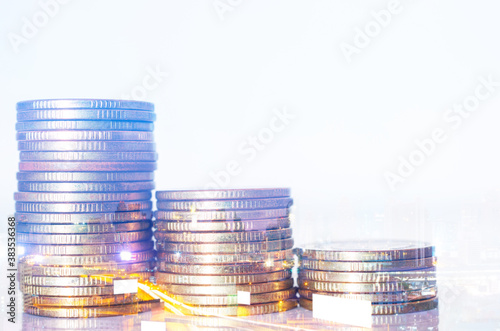 Double exposure of city background and rows of coins. business financial for investment and banking concept.