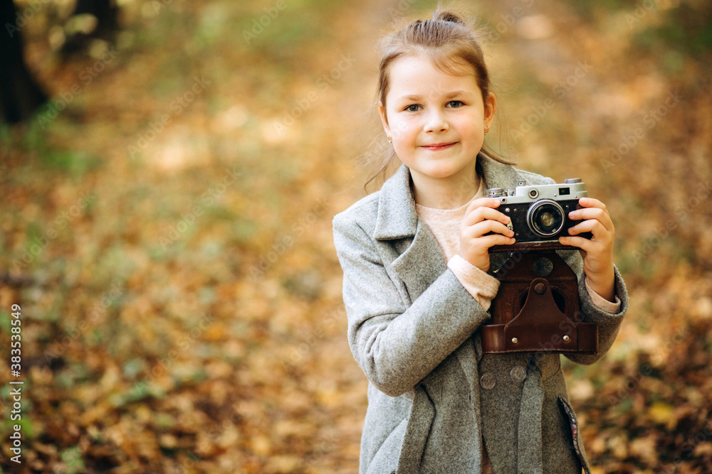 Beautiful girl with a camera walks in the woods with yellow and green autumn leaves. Autumn mood Beautiful girl with a camera walks in the woods with yellow and green autumn leaves. Autumn mood