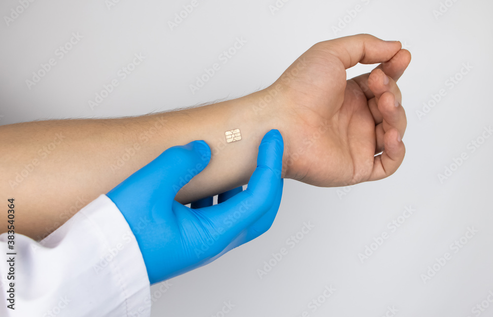 The cosmetic surgeon shows the patient's hand with a biological chip. The concept of cybernetics, biotechnology and high-tech future. Isolated on white The cosmetic surgeon shows the patient's hand with a biological chip. The concept of cybernetics, biotechnology and high-tech future. Isolated on white