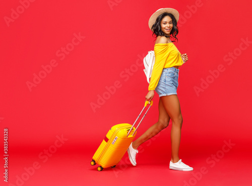 Obraz na plátně Ethnic traveler walking with suitcase.