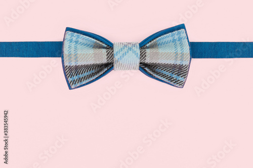 Handmade bow tie on an light pink background.