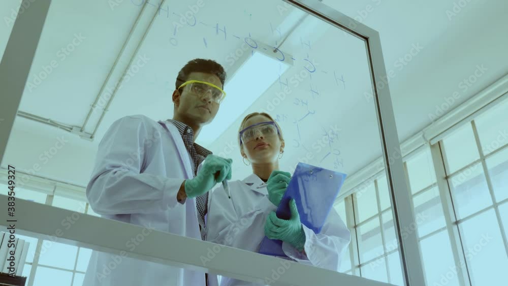 Two Scientist are writing a drug research formula in the laboratory. Doctor are Finding Chemical Formulas for Cancer Treatment or Coronavirus in Hospital. Concept Medical or Science technology 
