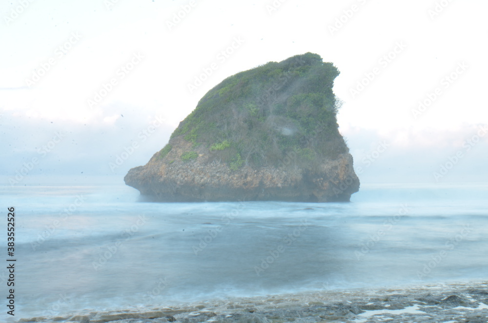 Long Exsposure at Sunrise at South Java Beach with Rock Cliff in the middle