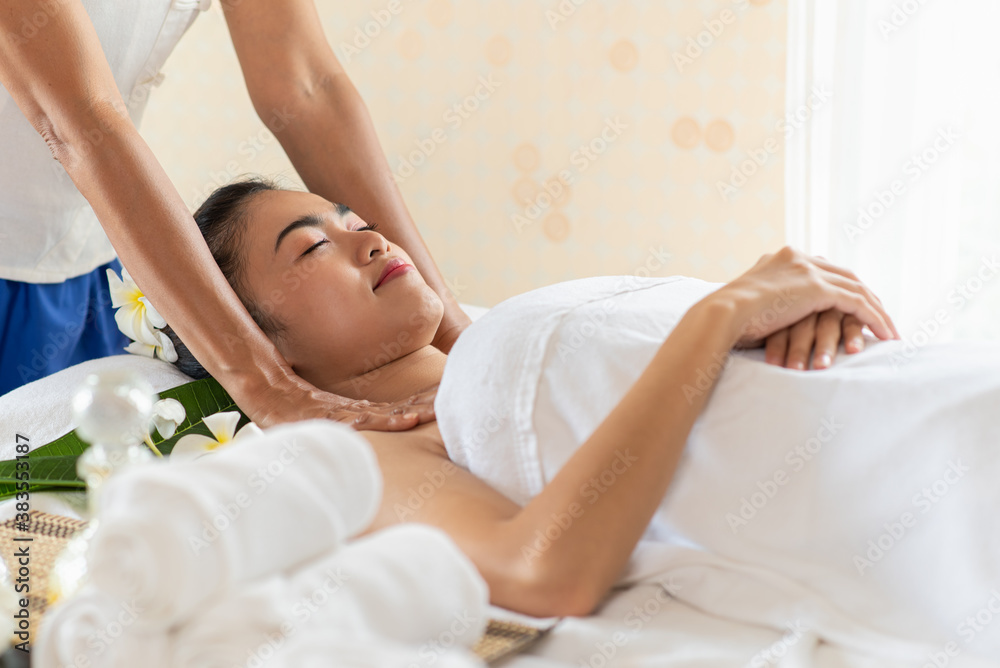 Obraz premium Young Asian woman getting massage in the spa salon, enjoying and relaxing
