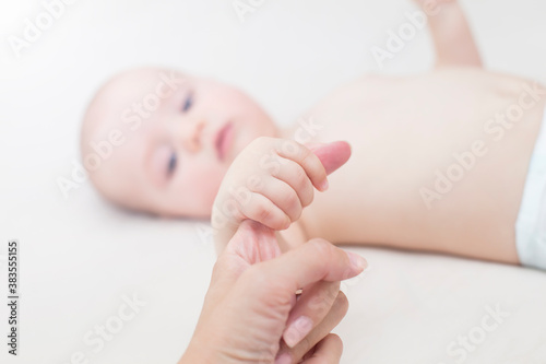 Baby girl holding mothers finger