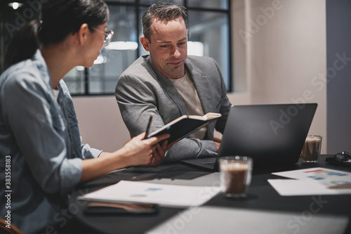 Two businesspeople working together at a table in an office