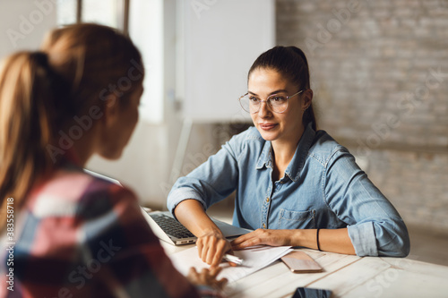 Insurance agent is aiming at the place where his customer need to sign in the office photo