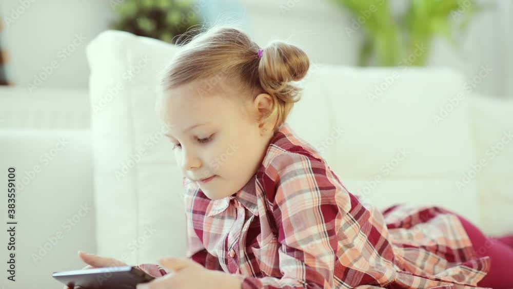 Cute preschool child girl playing with tablet at home due to coronavirus quarantine Cute preschool child girl playing with tablet at home due to coronavirus quarantine