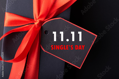 11.11 single's day sale concept. Online shopping concept. Black and red paper tag with ribbon on black background with copy space