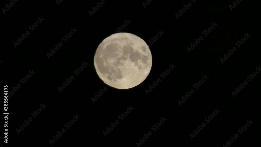 Full harvest moon crater surface closeup passing across dark night sky Full harvest moon crater surface closeup passing across dark night sky