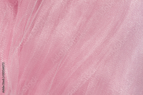 Pink tulle fabric texture top view. Coral background. Fashion color trends feminine tutu skirt flat lay, female blog backdrop for text signs desidgn. Girly abstract wallpaper, textile surface.