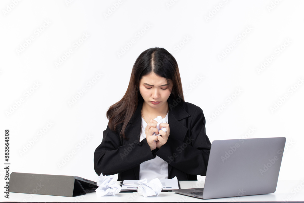 Picture of confused, tired and strain. Young Asian business woman wearing black suit sitting in the office and holding paper isolated on white background. Picture of confused, tired and strain. Young Asian business woman wearing black suit sitting in the office and holding paper isolated on white background.