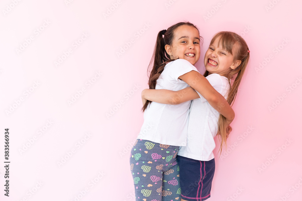 Two little girls - best friends, isolated over on a pink background Two little girls - best friends, isolated over on a pink background