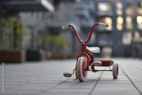 child three wheels bicycle in apartments yard photo