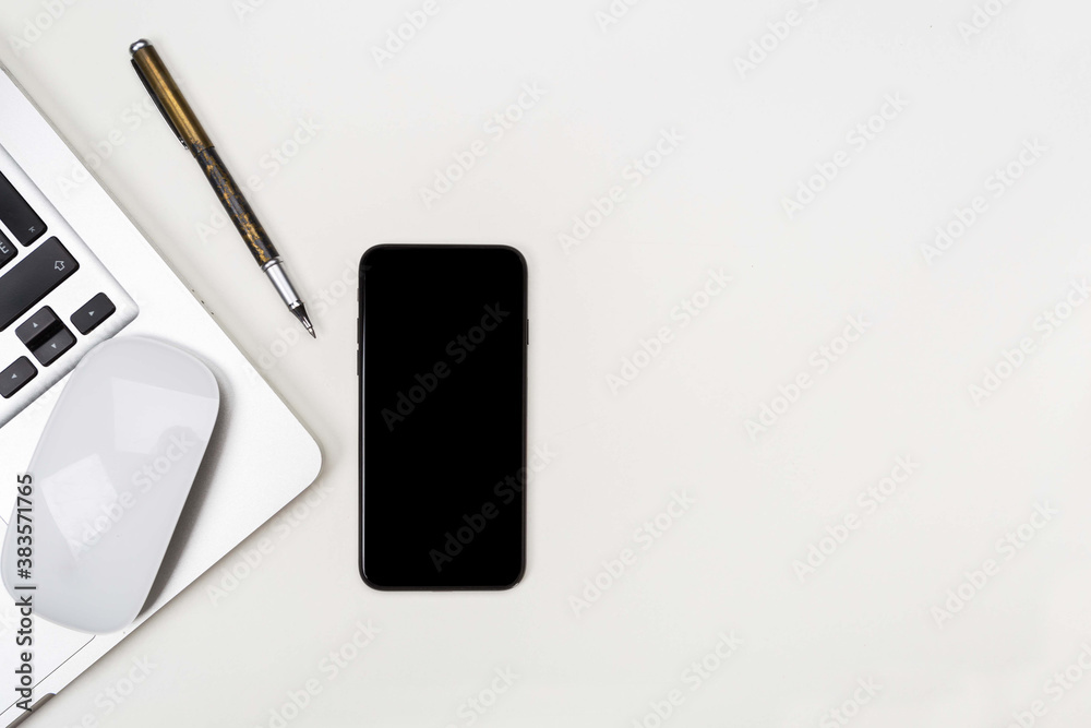 a phone with a screen mockup, with a computer mouse a coffee cup of writing supplies, a pens, a notepad on a white wooden table background. Top view of the work area, copy space a phone with a screen mockup, with a computer mouse a coffee cup of writing supplies, a pens, a notepad on a white wooden table background. Top view of the work area, copy space