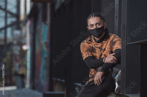 Mexican Latin young manl, urban portrait wearing black face mask
