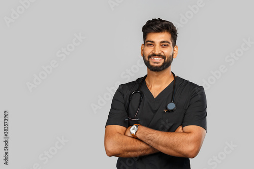 young indian male doctor or surgeon with stethoscope on gray background