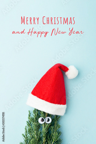 Concept of Christmas tree in Santa Claus's hat on blue background. New Year greeting card. photo