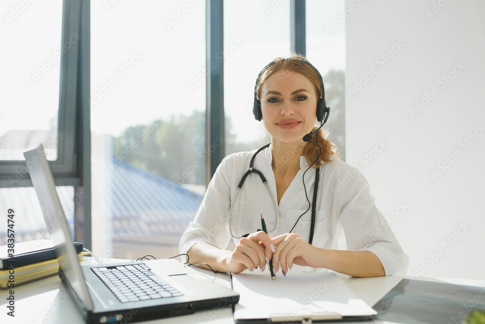 Young female doctor talking to patient online from medical office. Physician consulting client on video chat laptop at hospital Young female doctor talking to patient online from medical office. Physician consulting client on video chat laptop at hospital