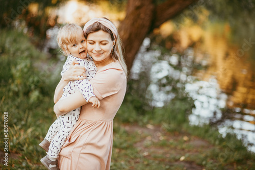 A mother holds her son in her arms on a summer day