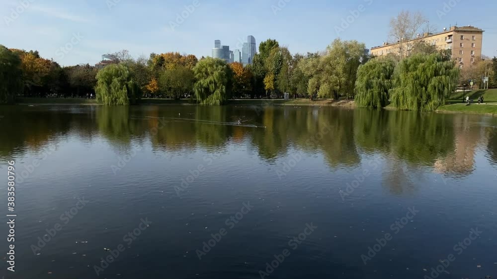 Beautiful scene of autumn park, trees, pond and skyscraper on a background. Beautiful scene of autumn park, trees, pond and skyscraper on a background.