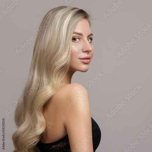 Blond woman on gray background. Hair care and coloring concept. Copycpase Wavy Hairstyle