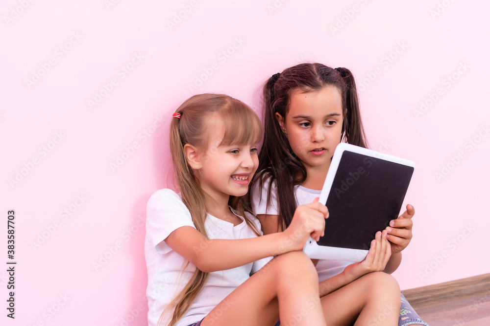 children, technology and home concept - two little girls with tablet pc computer on floor at home children, technology and home concept - two little girls with tablet pc computer on floor at home