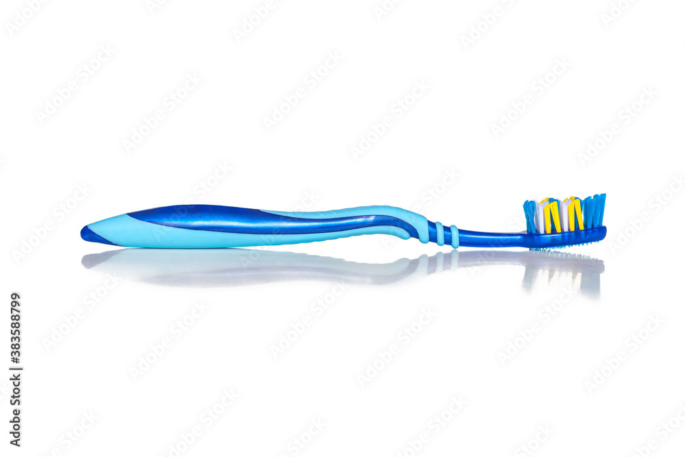 New toothbrush is reflected on the white surface of the table New toothbrush is reflected on the white surface of the table
