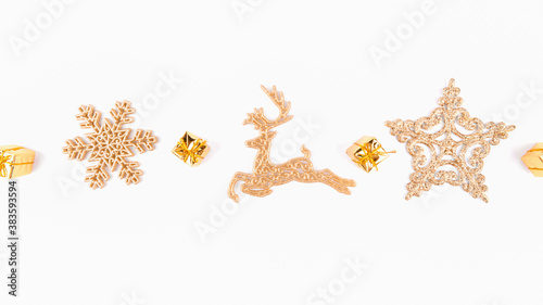Christmas background of golden star and golden reindeer decorations on white background, top view