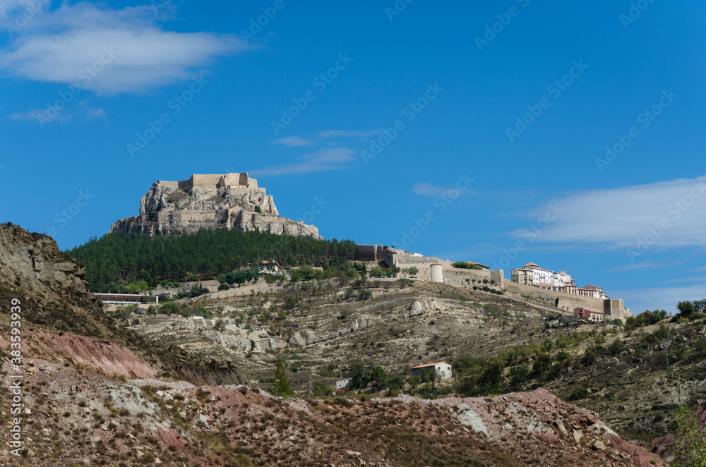 Landscape of the village of Morella with the walled city and the castle on the top of the hill on a day with blue sky and clouds, Morella, Castellon, Spain