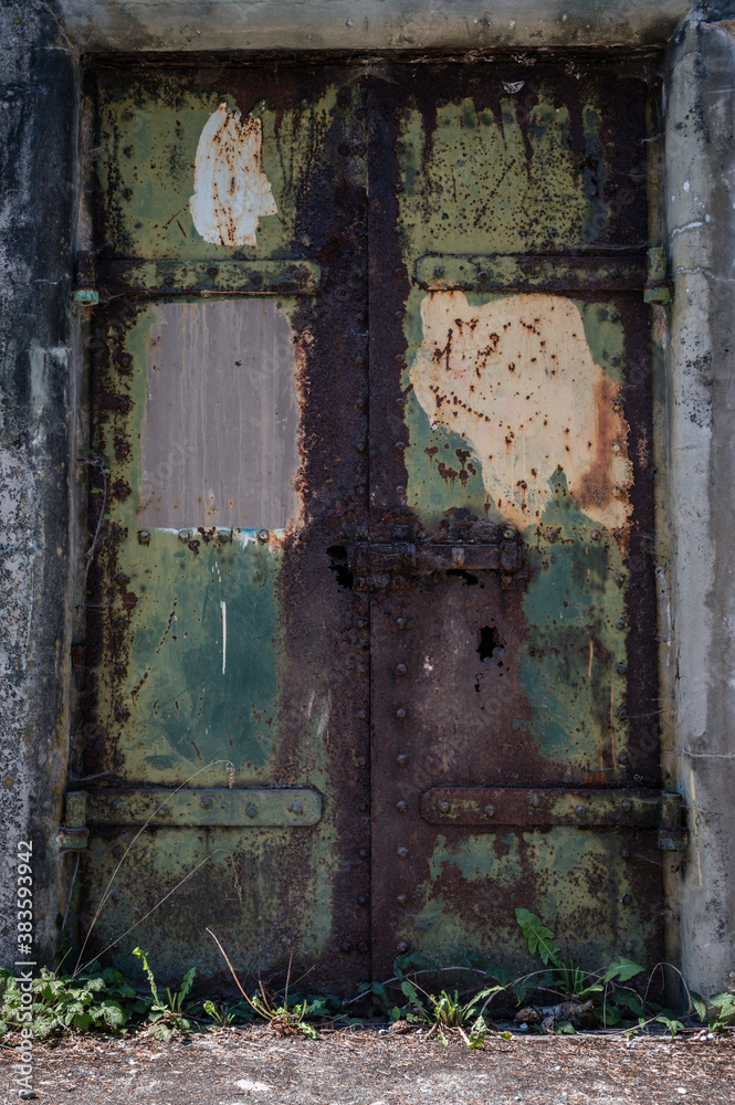 Rusty rustic metal door with green and yellow paint Rusty rustic metal door with green and yellow paint