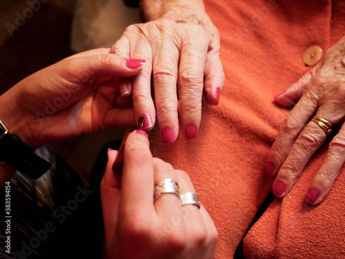 nail painting to the hand of an old woman
